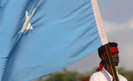 A protester carries the Somali national flag during a demonstration against Al-Shabaab militant group after last weekend's explosion in KM4 street in the Hodan district at the stadium Koonis in Mogadishu, Somalia October 18, 2017. REUTERS/Feisal Omar