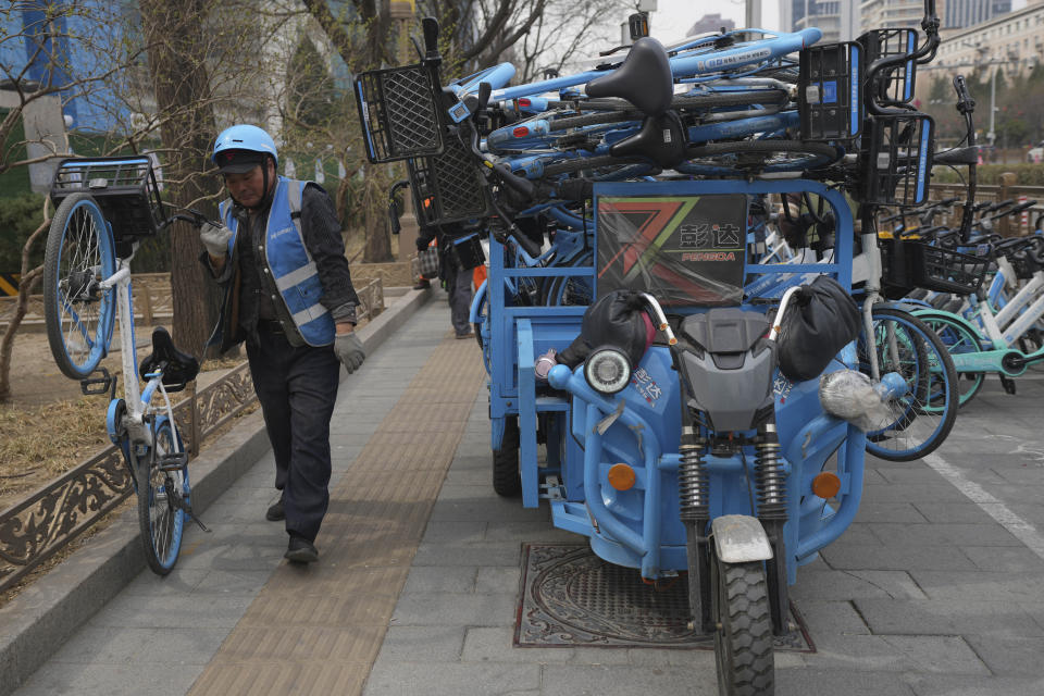 A worker unloads bicycles for a bike-share service in Beijing, China, March 21, 2024. China’s first generation of migrant workers played an integral role in the country's transformation from an impoverished nation to an economic powerhouse. Now, they're finding it hard to find work, both because they're older and the economy is slowing. (AP Photo/Tatan Syuflana)