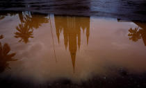 In this Saturday, Nov. 3, 2018, photo, the Immaculate Heart of Mary Cathedral is reflected in a puddle of water after a brief spell of rain in Kottayam in the southern Indian state of Kerala. An AP investigation has uncovered a decades-long history of nuns in India enduring sexual abuse from within the Catholic church. (AP Photo/Manish Swarup)