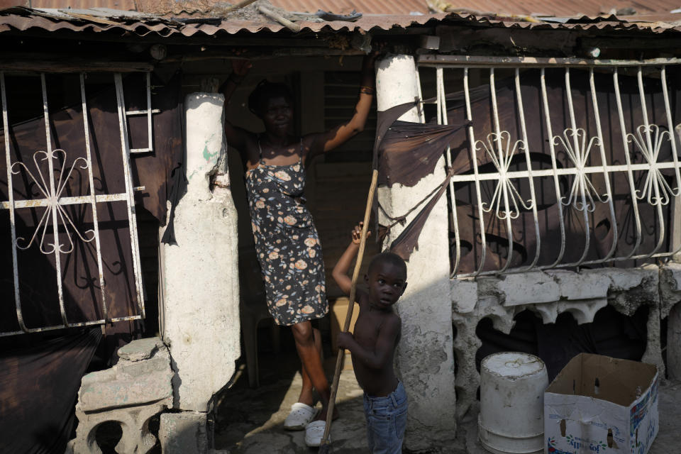 A Haitian mother and her son stand at the entrance of their home at the Eight batey in the Bahoruco province, Dominican Republic, Wednesday, May 15, 2024. The Dominican Republic bateyes are settlements of mostly Haitian immigrants and descendents working in the nearby sugarcane plantations. (AP Photo/Matias Delacroix)