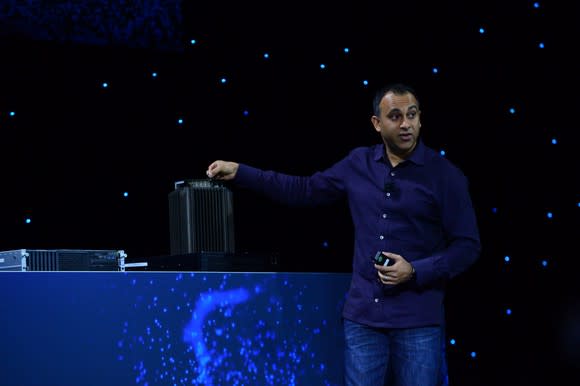 Intel data center chief with a 5G base station on stage.