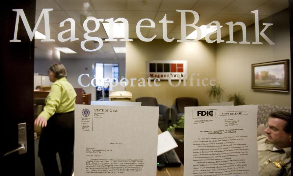 In this Monday, Feb. 2, 2009, file photo, FDIC, bank personnel and a sheriff deputy work inside the corporate office of MagnetBank in Salt Lake City. The banking industry has come a long way since the financial crisis struck in 2008. A sturdier economy, healthier loan portfolios, low interest rates, higher fees on bank accounts and a wave of mergers have combined to reduce the number of bank failures. (AP Photo/Douglas C. Pizac, File)