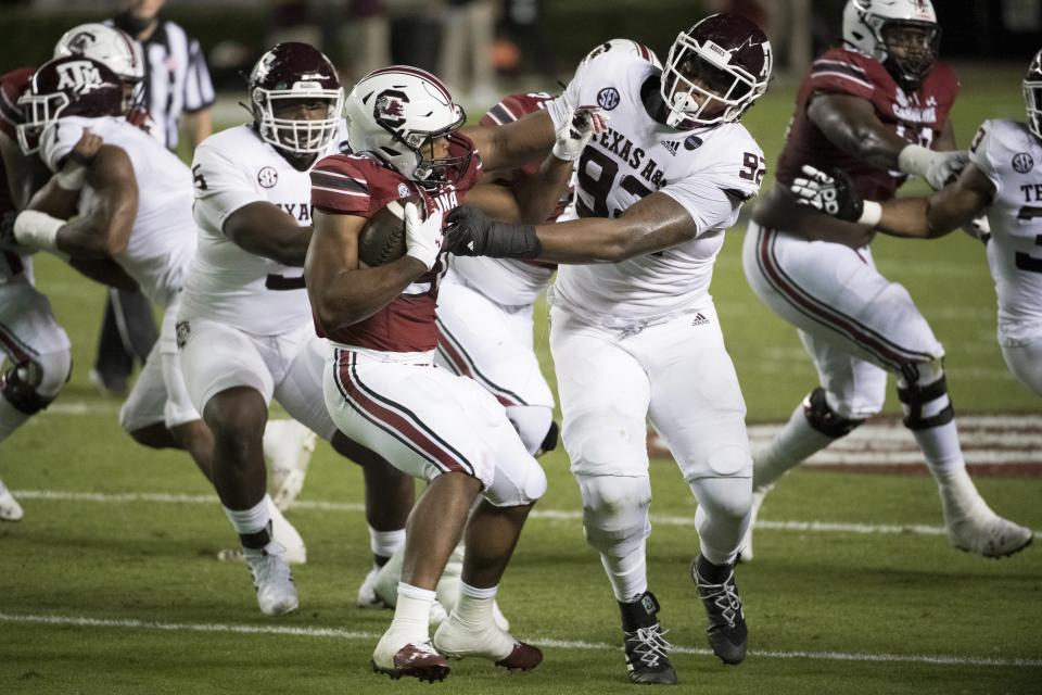 Texas A&M defensive lineman Jayden Peevy (92) tackles South Carolina running back Kevin Harris (20) during the first half of an NCAA college football game Saturday, Nov. 7, 2020, in Columbia, S.C. (AP Photo/Sean Rayford)