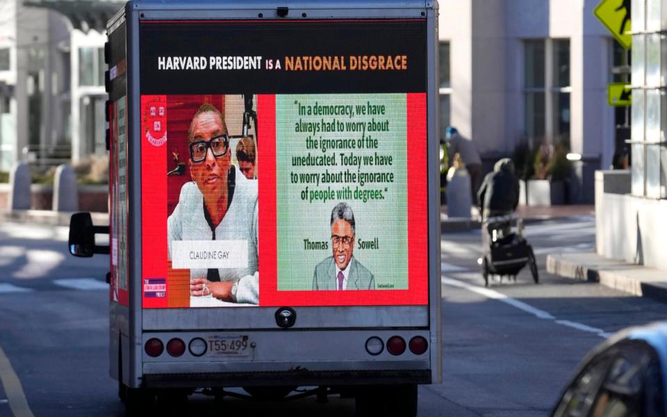 A truck carries an advert criticising Harvard through the streets of Cambridge, Mass