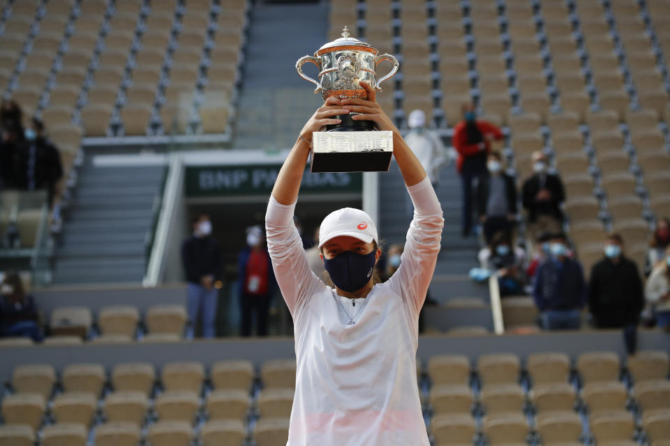 Poland's Iga Swiatek lifts the trophy after winning the final match of the French Open tennis tournament against Sofia Kenin of the U.S. in two sets 6-4, 6-1, at the Roland Garros stadium in Paris, France, Saturday, Oct. 10, 2020. (AP Photo/Christophe Ena)