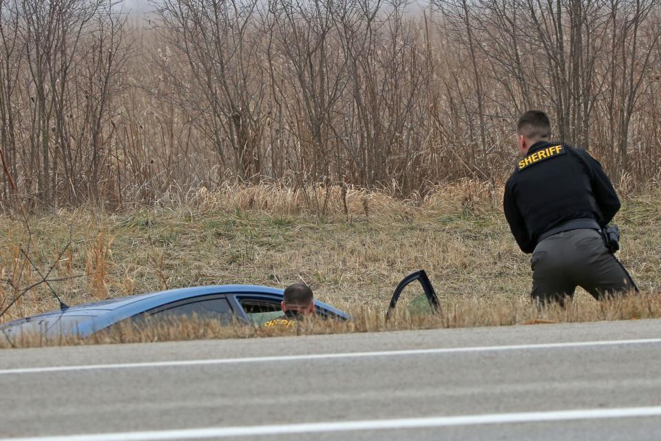 Ottawa County Sheriff's deputies apprehend the driver of a blue Toyota Prius that was involved in a high-speed chase on Ohio 2 in Ottawa County on Monday afternoon.