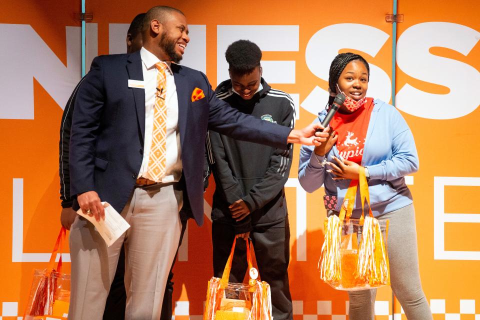 Anndrena Downs, right, answers a question posed by Redrick Taylor, UT's Director of Diversity Recruitment and Outreach for Undergraduate Admission, after learning she was accepted into the University of Tennessee at Knoxville and offered the Flagship Scholarship during an event at Austin-East Magnet High in Knoxville on Wednesday, Dec. 8, 2021. 