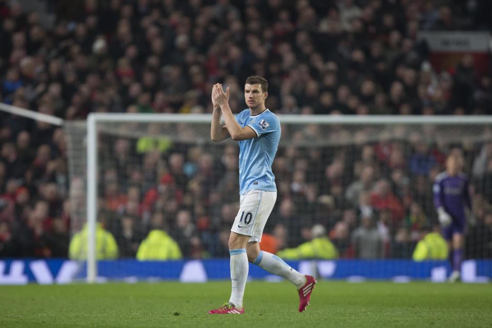 Manchester City's Edin Dzeko applauds supporters after being substituted during his team's English Premier League soccer match against Manchester United at Old Trafford Stadium, Manchester, England, Tuesday, March 25, 2014. Manchester City won the game 3-0 with two goals from Dzeko and one from Yaya Toure. (AP Photo/Jon Super)