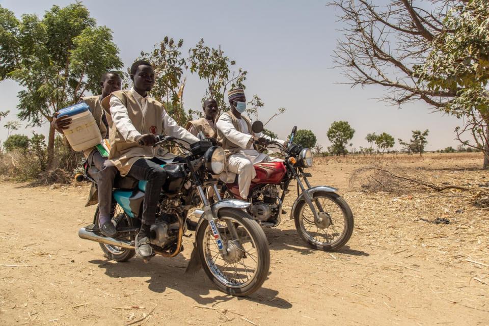 A mobile vaccination team travelling by motorbike to a remote community (Yagazie Emezi/Save The Children)