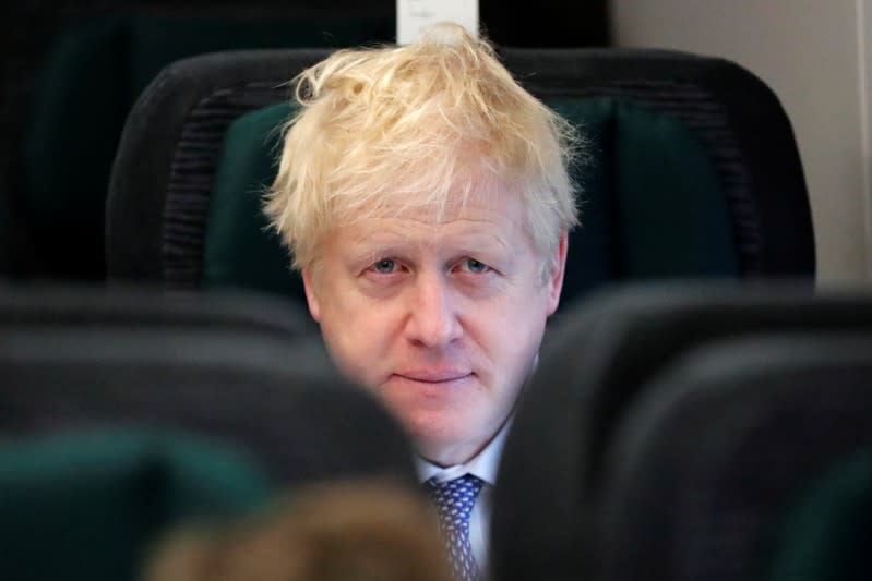 Britain's Prime Minister Boris Johnson looks up as he sits on a train, on his way to an election campaign event near Castle Cary