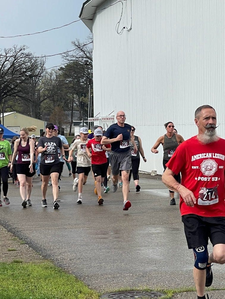 Runners make their way past the Grandstands at the Hillsdale County Fairgrounds during the 2023 CAPA Color 5K Run & Walk.