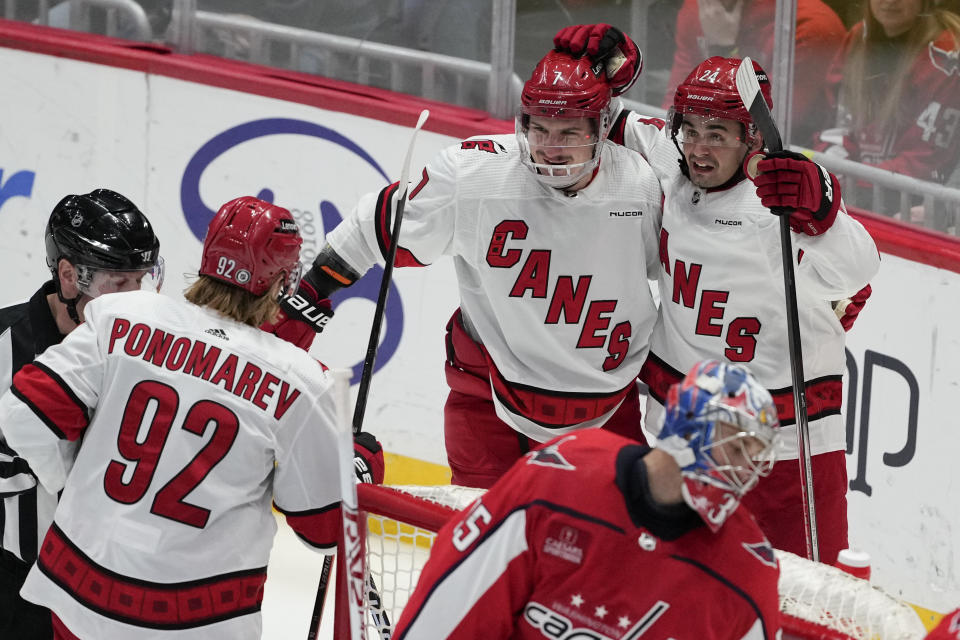 Carolina Hurricanes center Seth Jarvis (24) celebrates with defenseman Dmitry Orlov (7) and center Vasiliy Ponomarev (92) after scoring in the third period of an NHL hockey game against the Washington Capitals, Friday, Jan. 5, 2024, in Washington. (AP Photo/Mark Schiefelbein)