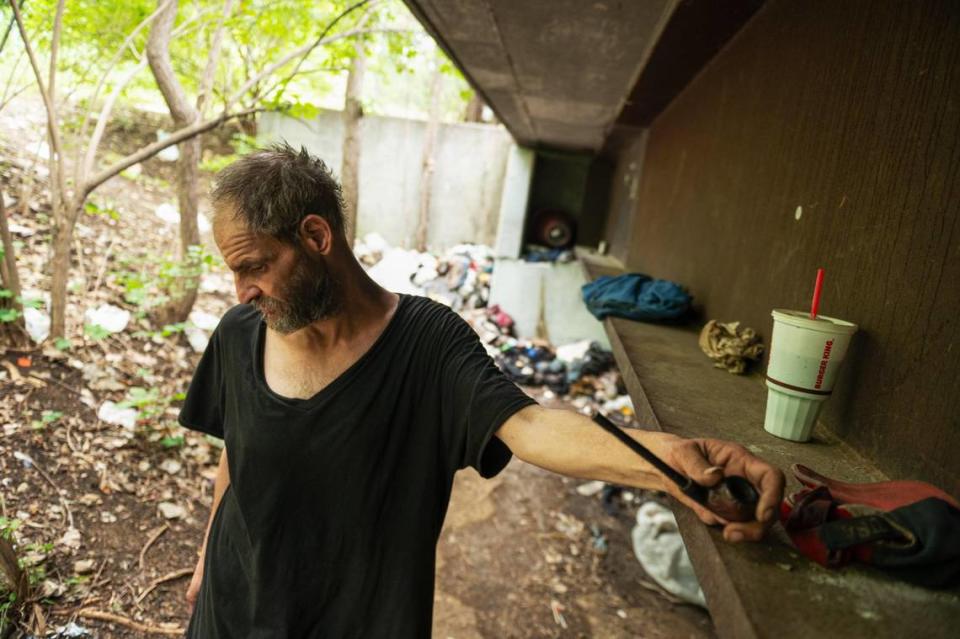 Ken Simard prepares to smoke his tobacco pipe under a bridge where he lives. Zachary Linhares/zlinhares@kcstar.com