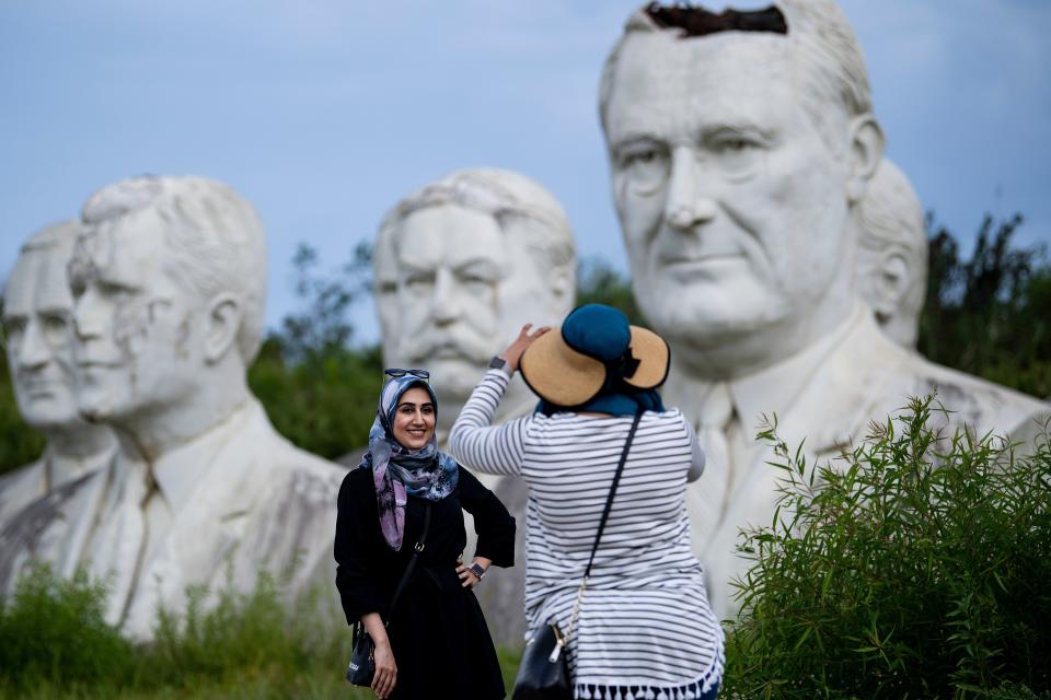 Zainab Jackson takes a photo of Ateeyeh Atefat in front of salvaged busts of former US Presidents August 25, 2019, in Williamsburg, Virginia. (Photo: Brendan Smialowski/AFP/Getty Images)