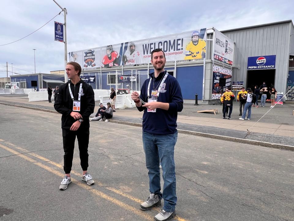 Volunteers hand out eclipse glasses at the Subaru World Championship Village, outside the Adirondack Bank Center, which is hosting the IIHF Women's World Championship in Utica, on Monday, April 8, 2024.