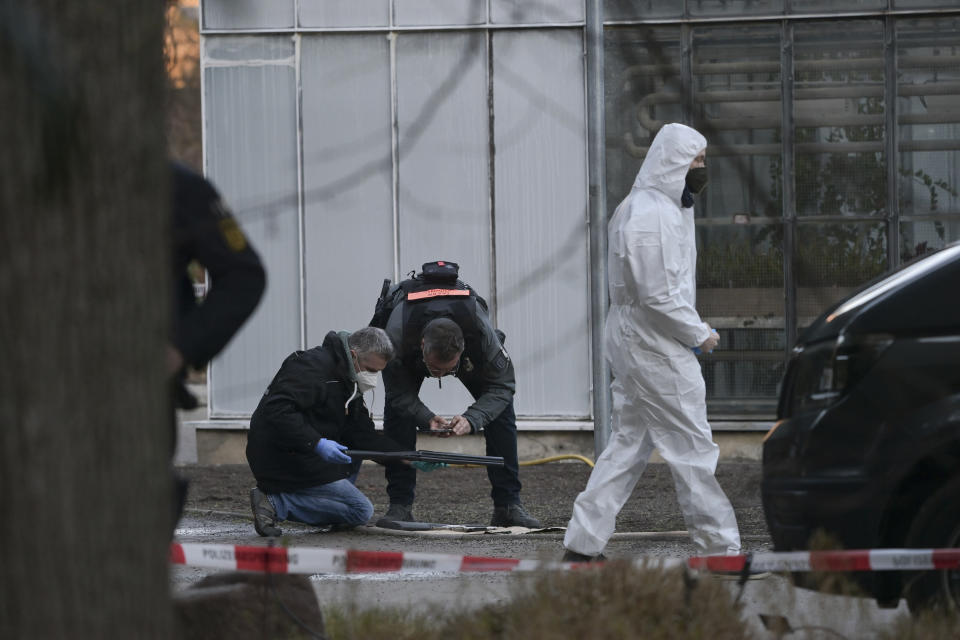 Police officers examine a weapon at the campus of Heidelberg University, Germany, Monday, Jan. 24, 2022. German police say a lone gunman has wounded four people at a Heidelberg University lecture hall in southwestern Germany. Police said that the perpetrator was dead after Monday's incident, but didn’t give details of how that happened. (Sebastian Gollnow/dpa via AP)