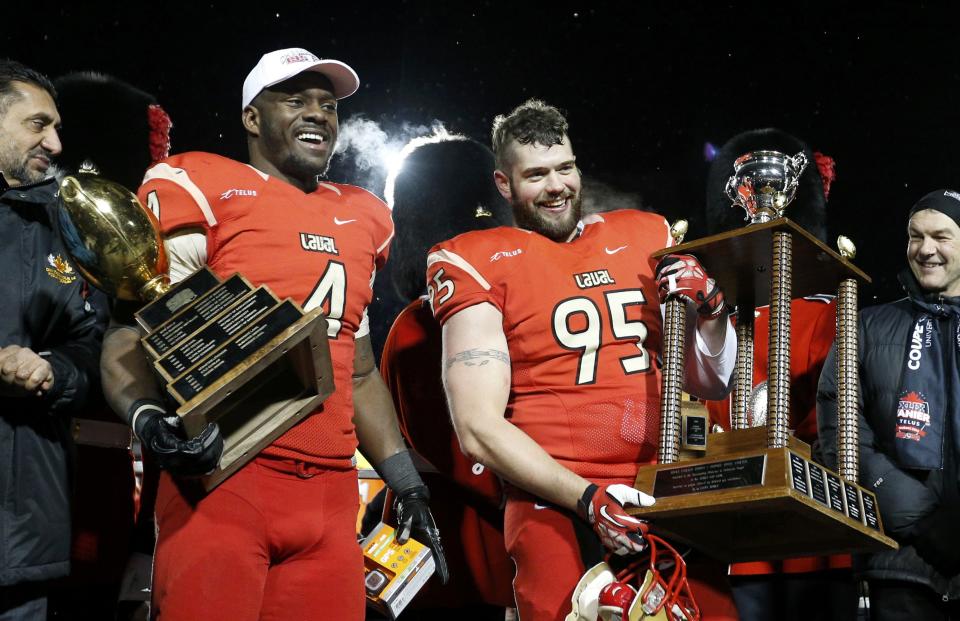 Laval Rouge et Or's Pascal Lochard (L) holds his trophy for best offensive player and Vincent Desloges holds his for best defensive player after they defeated the Calgary Dinos to win the Vanier Cup University Championship football game in Quebec City, Quebec, November 23, 2013. REUTERS/Mathieu Belanger (CANADA - Tags: SPORT FOOTBALL)