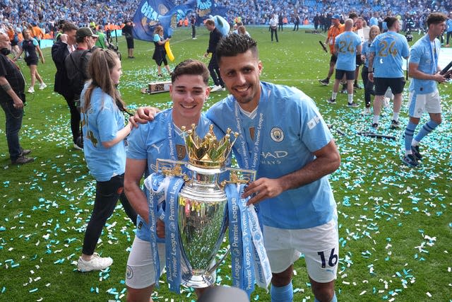 Julian Alvarez and Rodri hold the Premier League trophy