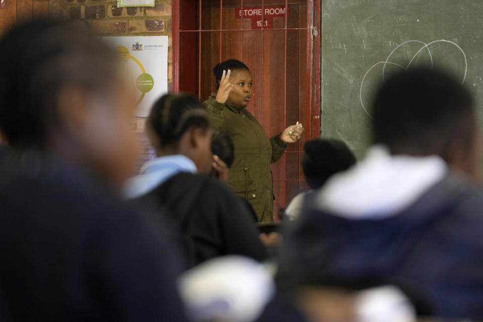 Lebohang Mphuthi assist students during a class at the Omar H.S. Ebrahim Primary School in Lotus Gardens, west of Pretoria, South Africa, Tuesday, July 25, 2023. South Africa's official unemployment rate of 33% is the highest in the world, and economists say it's even higher at 42% if you count those who have given up looking for work and have dropped off unemployment systems. (AP Photo/Themba Hadebe)