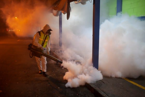 A city worker fumigates a market at night in the fight against the <em>Aedes aegypti </em>mosquito, which transmits the dengue virus, in Guatemala City, Guatemala, on Aug. 31, 2023.<span class="copyright">Sandra Sebastian—picture-alliance/dpa/AP</span>