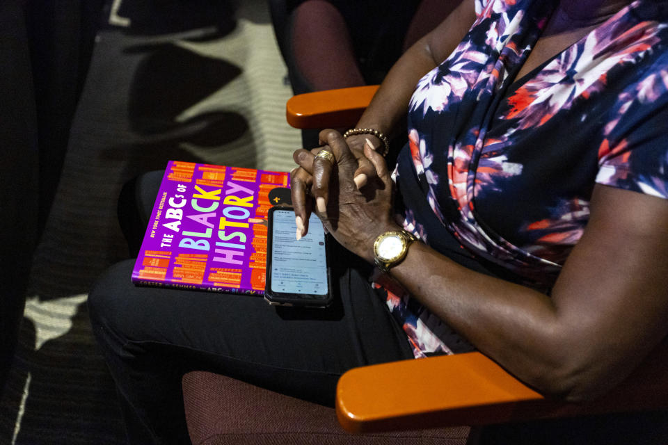 An attendee holds "The ABC's of Black History" during an education town hall regarding the state's newly adopted curriculum standards on African-American history at Antioch Missionary Baptist Church, Thursday, Aug. 10, 2023 in Miami Gardens, Fla. (D.A. Varela/Miami Herald via AP)
