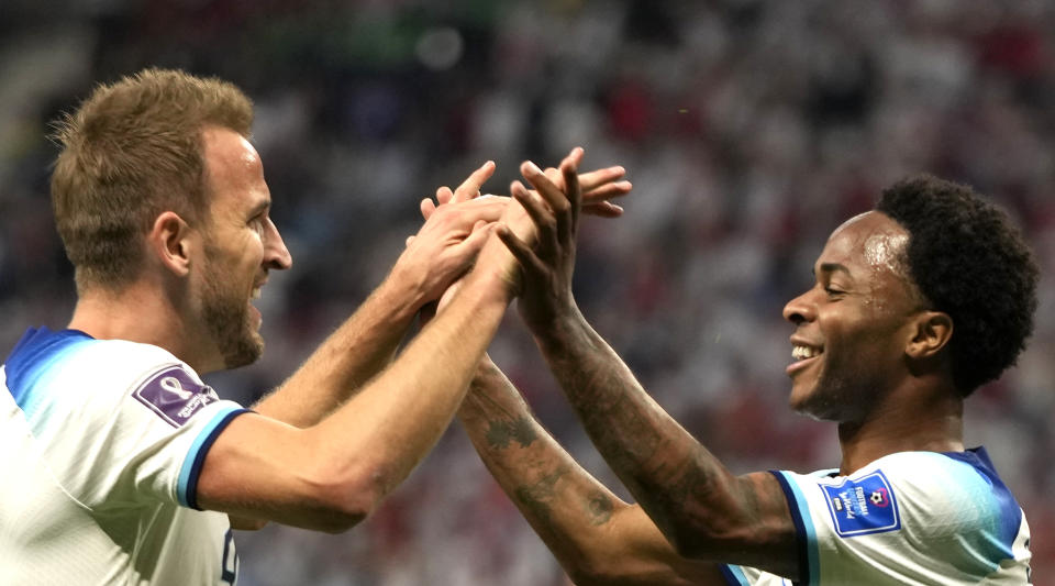 England's Raheem Sterling, right, celebrates with England's Harry Kane after scoring his side's third goal during the World Cup group B soccer match between England and Iran at the Khalifa International Stadium in Doha, Qatar, Monday, Nov. 21, 2022. (AP Photo/Frank Augstein)