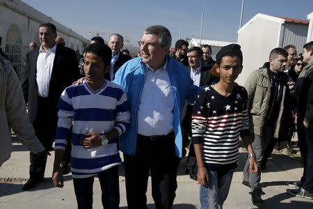 International Olympic Committee President (IOC) Thomas Bach (C) walks along with migrants during a guided media tour at the Eleonas refugee camp in Athens, Greece, January 28, 2016. REUTERS/Alkis Konstantinidis