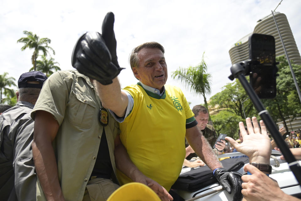 FILE - Brazil's President Jair Bolsonaro flashes a thumbs up as he greets supporters, wearing a Brazil soccer jersey, as he campaigns in Praca da Liberdade or Liberty Square, in Belo Horizonte, Brazil, Oct. 29, 2022. Soccer was a short-lived unifying force in Brazil, as Brazil exited the World Cup tournament earlier than expected, but Bolsonaro's backers are still sporting the national colors. (AP Photo/Yuri Laurindo, File)