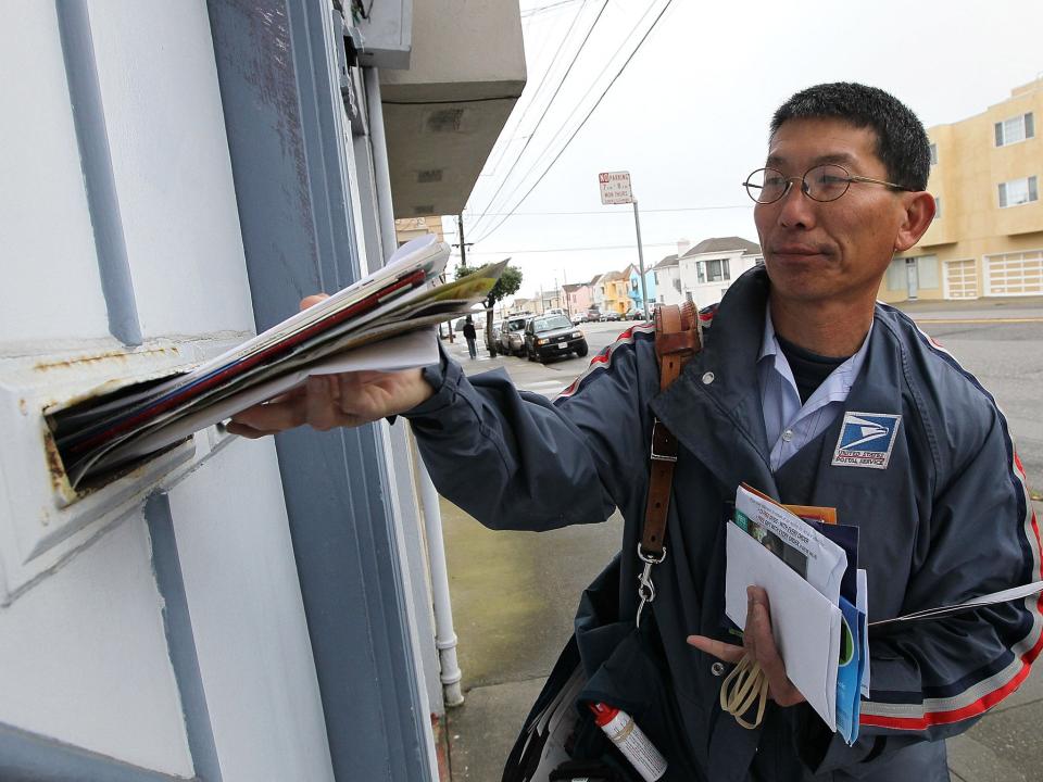 US Postal Service lettercarrier Raymond Hou delivers mail along his route: Getty Images