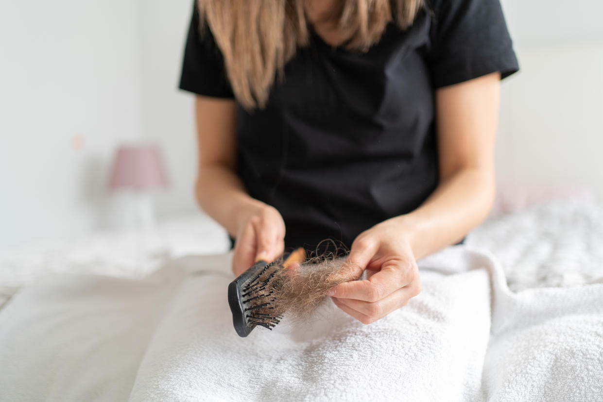 Woman Cleaning Her Hair With A HairBrush Ä°n Her Hand