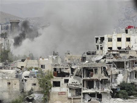 Smoke rises from behind a building in Jobar, Damascus September 18, 2013. Picture taken September 18, 2013. REUTERS/Msallam Abd Albaset