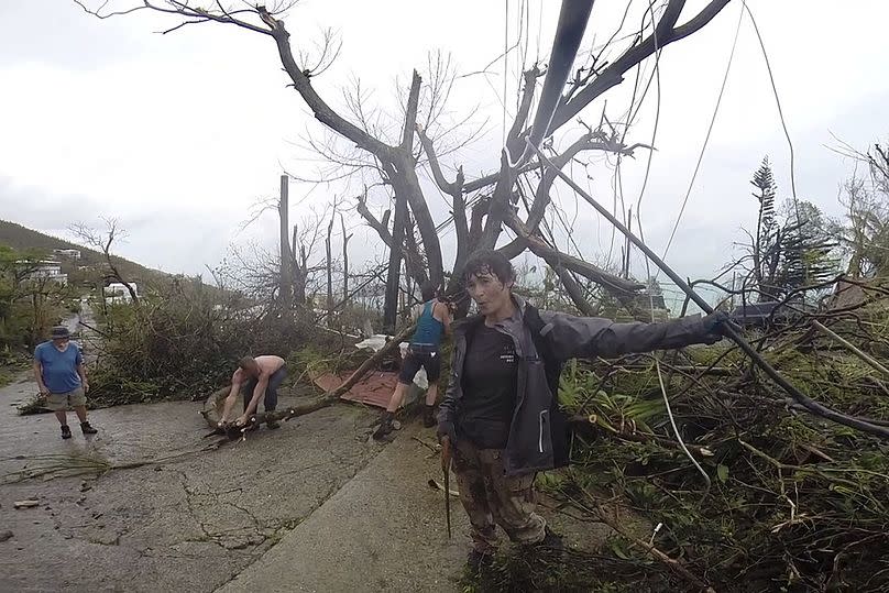 Neighbours clear debris from the road in the aftermath of Hurricane Irma, in St. Thomas, USVI, September 2017.