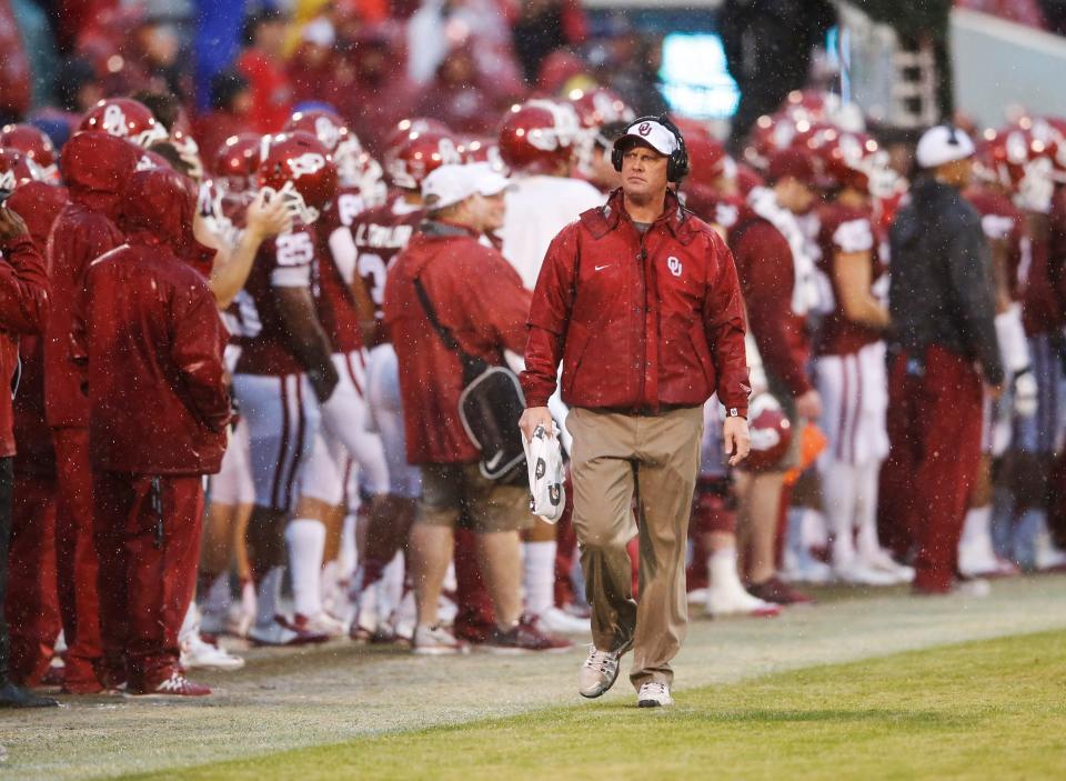 Oklahoma assistant coach coach Cale Gundy walks on the sideline during the team's game against Kansas at Gaylord Family - Oklahoma Memorial Stadium.