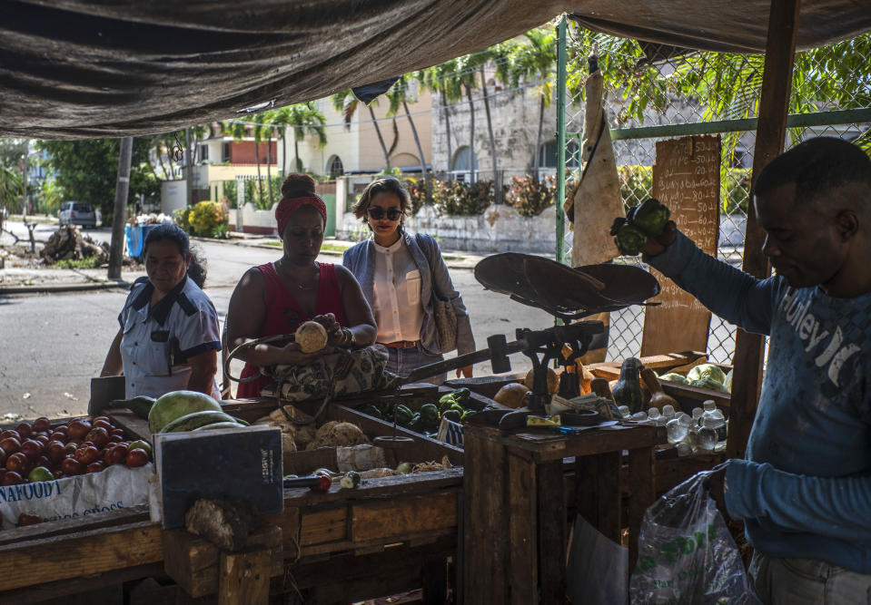 Congressional candidates Denisse Ricardo, stops at a vegetable stall while campaigning in Havana, Cuba, Tuesday, March 21, 2023. Some eight million Cubans will vote on Sunday, March 26, for the deputies that will make up the People's Power National Assembly, a unicameral parliament. (AP Photo/Ramon Espinosa)