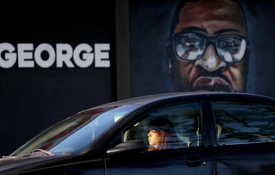 A likeness of George Floyd faces Artesia Boulevard in North Long Beach as a motorist waits for traffic to move.