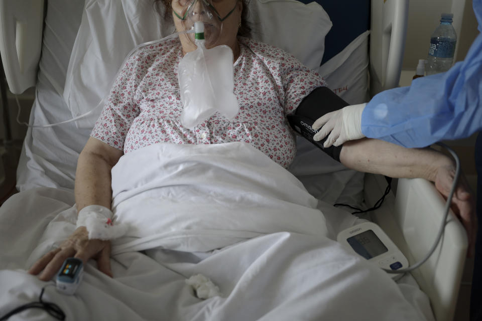 FILE - a patient breathes through an oxygen mask in the COVID-19 section of the University Clinical Centre hospital in Banja Luka, Bosnia, Nov. 4, 2021. The pandemic is again roaring across parts of Western Europe, a prosperous region with relatively high vaccination rates and good health care systems but where lockdown measures to rein in the virus are largely a thing of the past. Soaring infections in eastern Europe are blamed on vaccine skepticism and low rates of inoculation. While rates are higher in the west, they appear to have hit a plateau in some nations and vaccine holdouts also are a factor in spiking infections. (AP Photo, file)