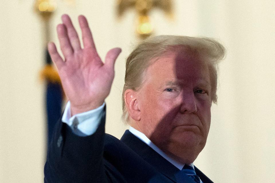 President Donald Trump waves from the Blue Room Balcony in October