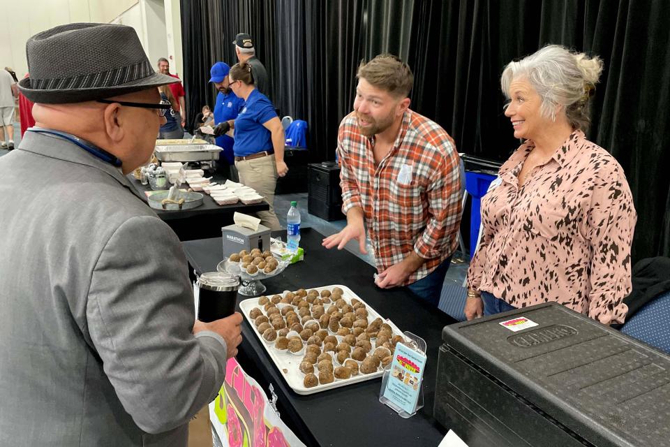 Alex Coleman (center) and CareySue Beasley from Okaloosa Donuts talk with Dan Diamond of Diamond Dan DJ Services during Thursday's Winter Guest Fest at Destin-Fort Walton Beach Convention Center. The annual event brings together wintering snowbirds with local restaurants, resorts, retailers, hotels and other businesses.