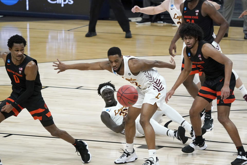 Loyola Chicago guard Marquise Kennedy (12) fights for a loose ball with Oregon State guard Gianni Hunt (0) and guard Ethan Thompson, right, during the first half of a Sweet 16 game in the NCAA men's college basketball tournament at Bankers Life Fieldhouse, Saturday, March 27, 2021, in Indianapolis. (AP Photo/Jeff Roberson)