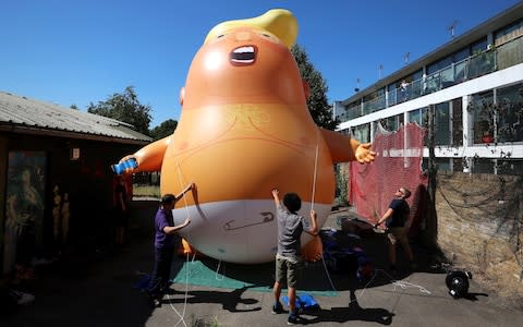 People inflate a helium filled Donald Trump blimp to be deployed during The President of the United States' upcoming visit to the UK - Credit:  Simon Dawson/Reuters