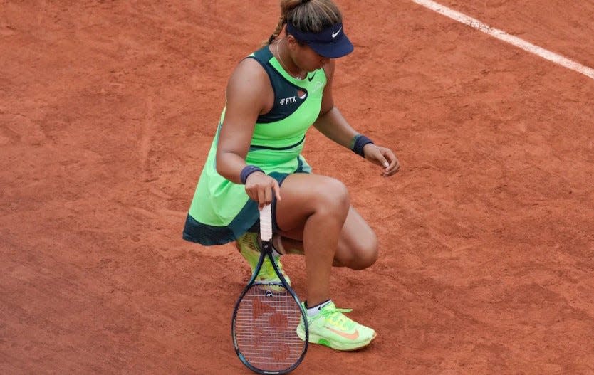 Naomi Osaka tries to stretch her injured Achilles tendon at last month's French Open.