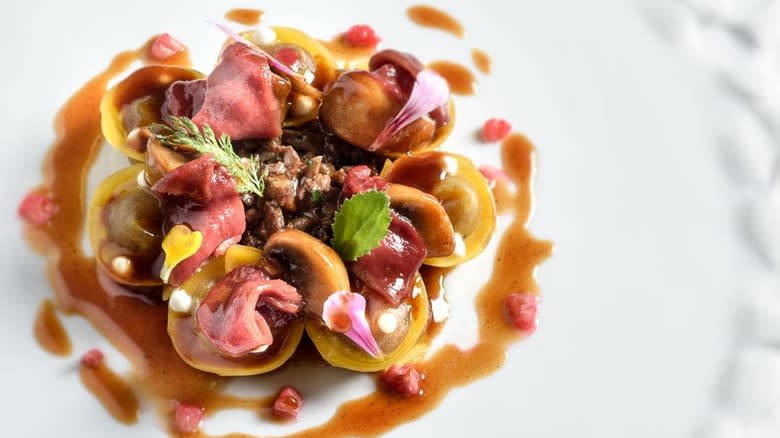 homemade cappellacci with pigeon giblets on white plate