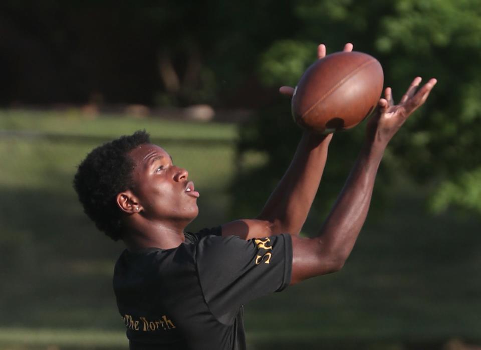 Zi'Velle Thomas, A North High football player, catches a pass during the first annual Sonil Haslam Community Youth Football Camp at North High School on Wednesday.