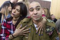 Israeli soldier Elor Azaria is embraced by his mother at the start of his sentencing hearing in Tel Aviv, Israel, Tuesday, Feb. 21, 2017. The court sentenced Azaria to 18 months in prison for the fatal shooting of a wounded Palestinian assailant. The Palestinian, Abdel Fattah al-Sharif, was lying on the ground badly wounded and already unarmed when Azaria shot him in the head. Prosecutors had asked that Sgt. Elor Azaria be sentenced to 3-5 years in prison. (Jim Hollander, Pool, via AP)