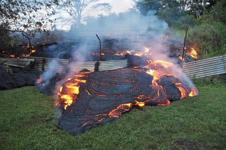 The lava flow from the Kilauea Volcano burns vegetation as it approaches a property boundary in a U.S. Geological Survey (USGS) image taken near the village of Pahoa, Hawaii, October 28, 2014. REUTERS/U.S. Geological Survey/Handout