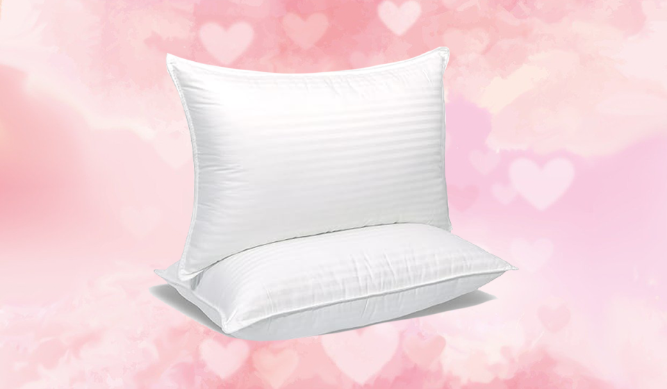 Two queen pillows on a pink background with hearts.