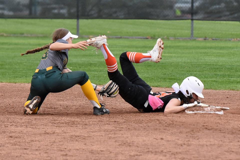 Brighton's Sydney Scoggins dives safely head-first into second base before Howell shortstop Addison Caldwell can apply the tag on Monday, May 8, 2023.