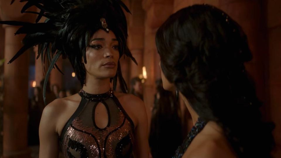 Phillipa in a feathered headdress speaks to Yennefer on The Witcher