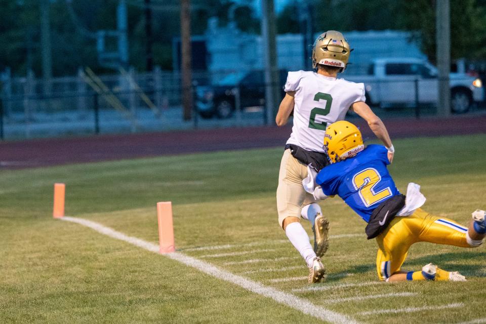 St. Mary Catholic Central quarterback Ian Foster gets past Luke Beaudrie to score a touchdown on the Falcons' first offensive play of the night. SMCC won 41-14.