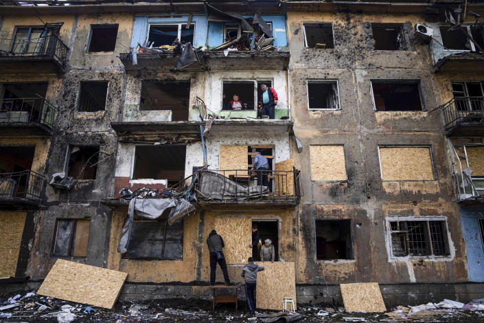 FILE - Local residents close the windows of an apartment building with plywood after Russian shelling in Dobropillya, Donetsk region, in eastern Ukraine, April 30, 2022. An interminable and unwinnable war in Europe? That's what NATO leaders fear and are bracing for as Russia's war in Ukraine grinds into its third month with little sign of a decisive military victory for either side, and no resolution in sight. (AP Photo/Evgeniy Maloletka, File)